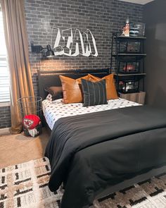 a bedroom with brick walls and black bedding