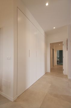 an empty room with white walls and doors on both sides is seen in this image