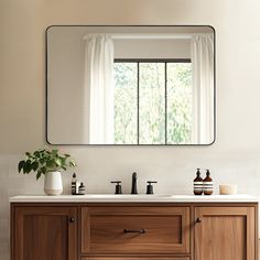 a bathroom vanity with a large mirror above it