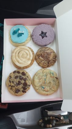 a pink box filled with lots of different types of cookies