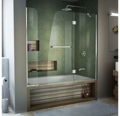 a bathroom with a glass shower door and green tile on the wall, along with a rug