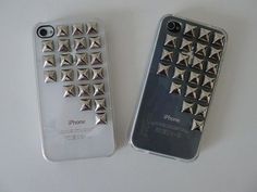 two cell phones with spikes on them sitting next to each other, one is silver and the other is white