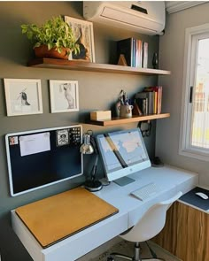 a desk with a laptop computer sitting on top of it next to a book shelf