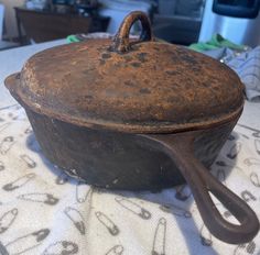 an old cast iron skillet sitting on top of a white tablecloth covered table