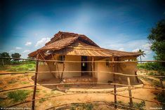 a small hut with a wooden fence around it