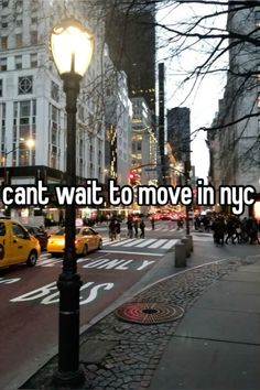 a city street filled with lots of traffic next to tall buildings and people walking on the sidewalk