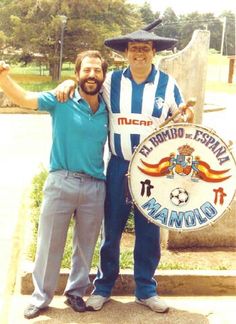 two men standing next to each other in front of a sign