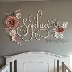 a white crib with flowers and the word sonja painted on it's wall