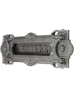 a metal sign that says letters on the front and back of it, with an ornate design