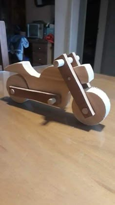 a wooden toy motorcycle sitting on top of a table