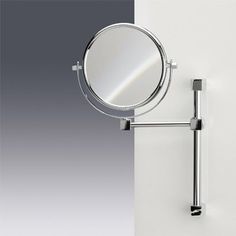 a wall mounted magnifying mirror on the side of a white and gray wall