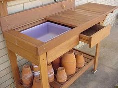 an outdoor kitchen with pots and pans on the counter top, in front of a brick wall