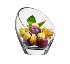 a glass bowl filled with fruit on top of a table