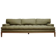 a green couch with four pillows on it's back and two arms, sitting against a white background