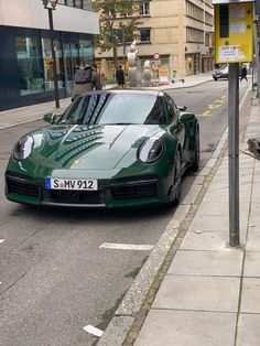 a green sports car parked on the side of the road next to a parking meter