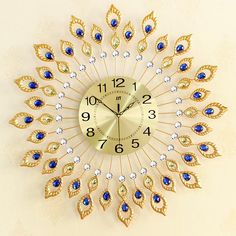 a gold clock with blue and white jewels on it's face is shown in the shape of a peacock