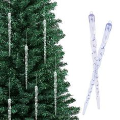 a small christmas tree next to a pair of snow - covered skis with icicles hanging from it