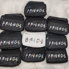 six black lunch bags with the words friends written on them in white letters, sitting on a fluffy surface