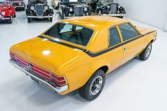 a yellow car parked in a garage next to other cars