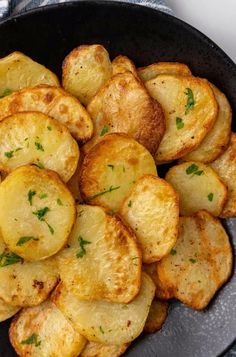 cooked potatoes in a skillet with parsley on the top, ready to be eaten