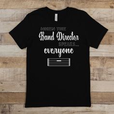 "Strike the perfect chord of respect and humor with our \"When The Band Director Speaks... Everyone Listens\" T-shirt. This design is a playful nod to the authoritative voice of a band director, whose every word can pause an entire ensemble. Ideal for band directors who lead with both precision and wit. 🎼🤫 PLEASE CHECK THE SIZE CHART! We cannot offer refunds or exchanges if you order the wrong size. Materials: * 100% combed and ring-spun cotton (Heather colors contain polyester) * Ash color is 99% combed and ring-spun cotton, 1% polyester * Heather colors are 52% combed and ring-spun cotton, 48% polyester * Athletic and Black Heather are 90% combed and ring-spun cotton, 10% polyester * Heather Prism colors are 99% combed and ring-spun cotton, 1% polyester * Fabric weight: 4.2 oz (142 g/m Band Director Gifts, Director Gifts, Funny Marching Band, Marching Band Shirts, Band Teacher, Marching Band Humor, Band Director, Music Teachers, Music Teacher Gifts