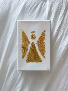 a piece of art that has been made to look like an angel with gold wings