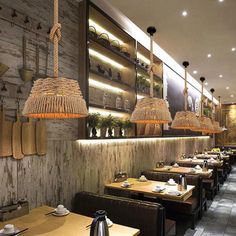 the interior of a restaurant with wooden tables and hanging baskets on the wall above them