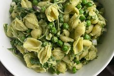 a white bowl filled with pasta and peas