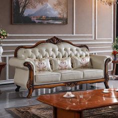 a living room filled with furniture next to a painting on the wall and coffee table