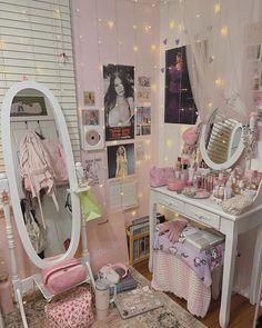 a bedroom with a vanity, mirror and lights on the ceiling is decorated in pastel pinks