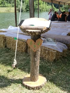 a tree stump with a heart cut out of it sitting in front of some hay bales