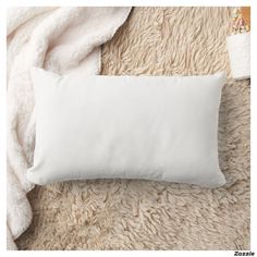 a white pillow sitting on top of a bed next to a blanket