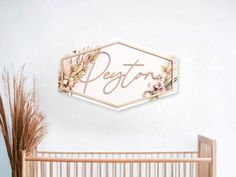 a baby crib next to a white wall with a wooden sign that says degtora on it