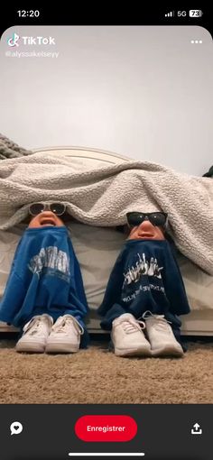 two people laying on top of a bed with their feet up and one person wearing sunglasses