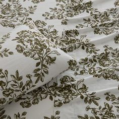 a white and brown floral print bed sheet with two pillow cases on top of it