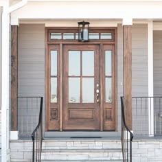 the front door to a house with two black wrought iron railings