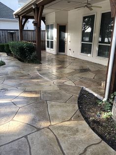 an outdoor patio with flagstone pavers and stone walkway leading to the front door