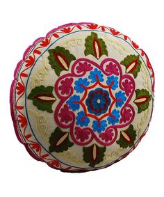 an embroidered round pillow with colorful designs on it's sides and the bottom half