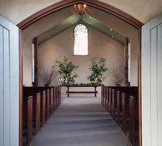 the inside of a church with pews and flowers in vases on each side