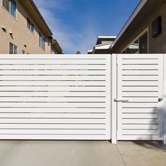 a tall white fence next to a building