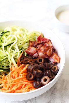 a bowl filled with lots of different types of food on top of a white table