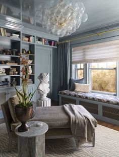 a living room filled with furniture and a large window covered in glass balls hanging from the ceiling