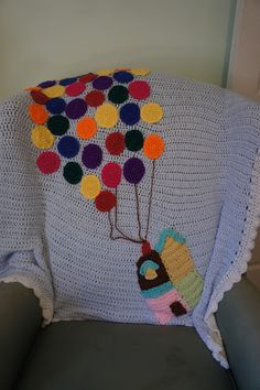 a crocheted hot air balloon blanket on a chair