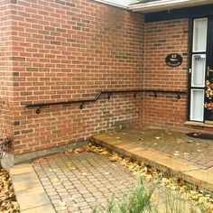 a brick building with a black door and window