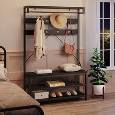 a bed room with a neatly made bed and a coat rack