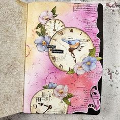 an altered clock with flowers on it is sitting next to a piece of paper that has been cut out