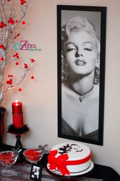 a table topped with a cake covered in frosting next to a red candle and framed photograph