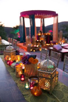 a long table topped with lots of lit candles