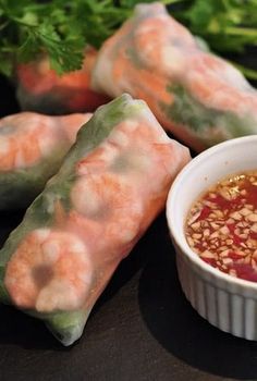 some food is sitting on a table with dipping sauce in the bowl and garnished with parsley