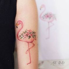 a pink flamingo with flowers on its arm